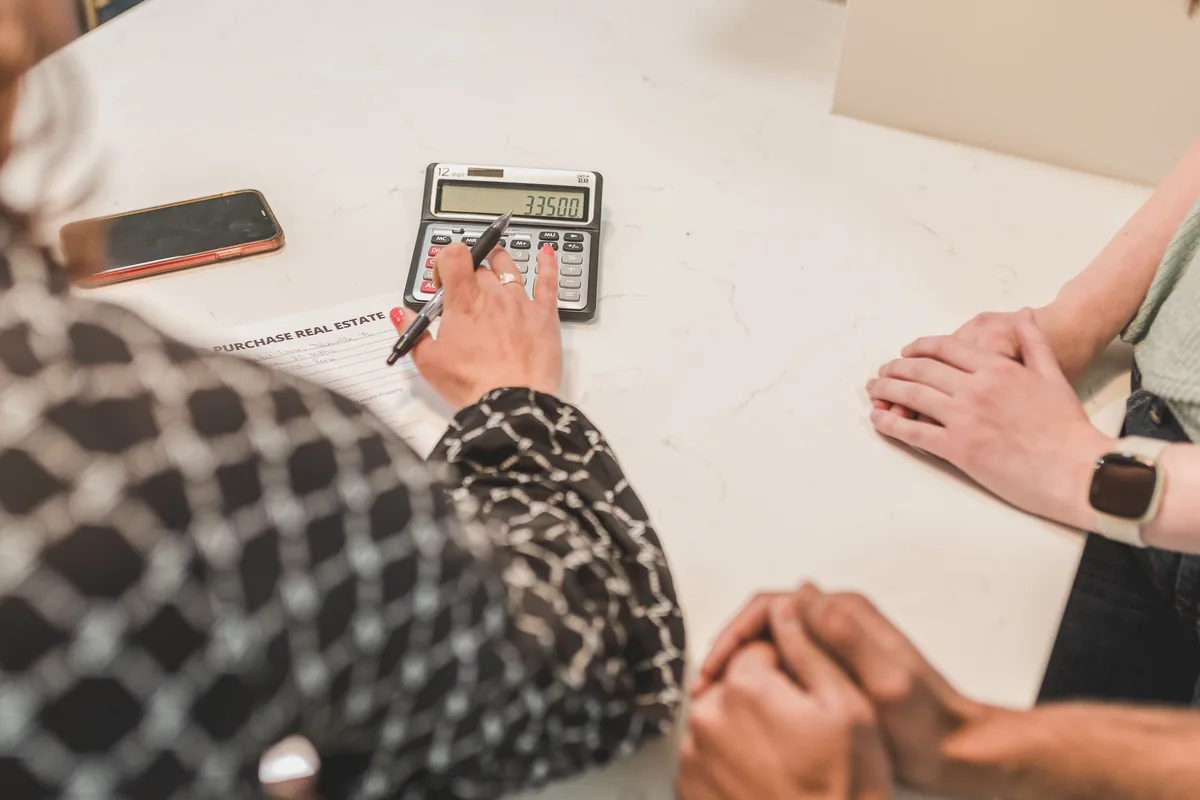 A property transaction being reviewed with documents and a calculator
